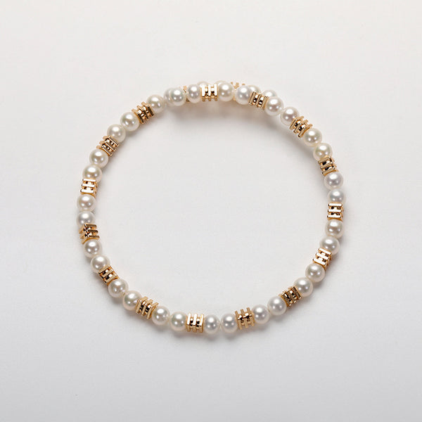 Freshwater seed pearl bracelet with 4-5mm pearls and gold spacer beads on white background