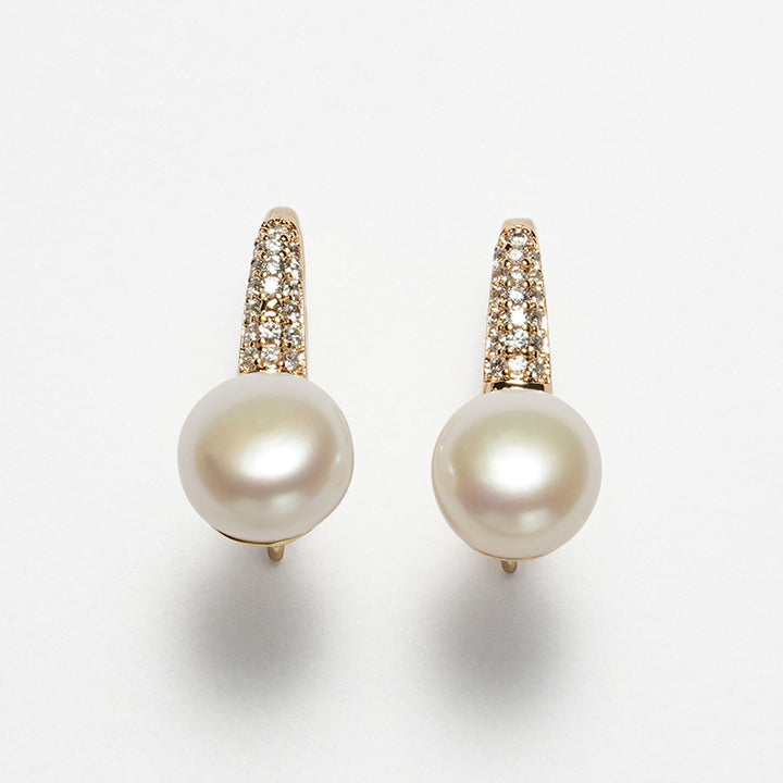 Close-up image of 8mm round white freshwater pearl earrings with a gold-tone stiletto heel-inspired hook design and pavé-set crystals.
