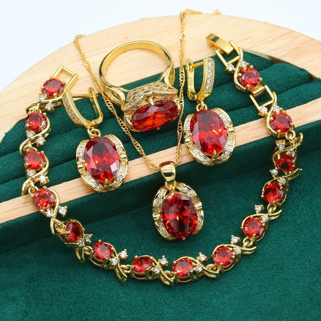 Gold-plated women’s jewelry set with oval green zirconia, including necklace, earrings, bracelet, and ring